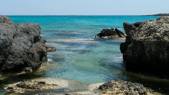 Video of the blue lagoon of Elafonisi beach with white and pink sand and black rocks. Crete. Greece