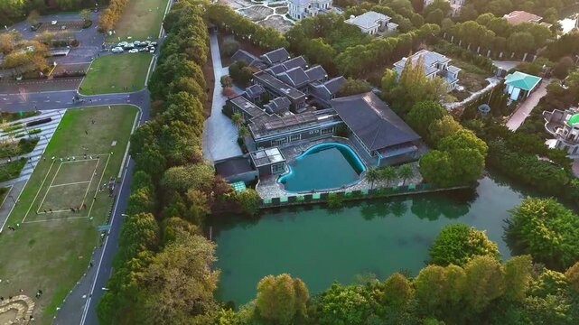 Forward Drone Flight Toward Lakeside Buildings and Swimming Pool