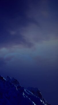 As day softly transitions to night, the mountain peaks glow gently in twilight. The sky dances with shades of blue and purple, creating a peaceful moment in nature&rsquo;s embrace.