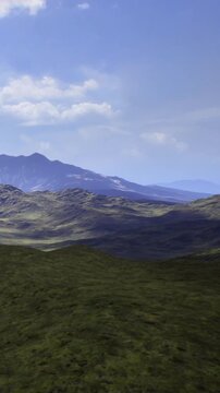 Rolling green hills stretch towards towering mountains, bathed in soft sunlight. A peaceful afternoon scene showcases natures beauty and tranquility, inviting exploration and wonder.