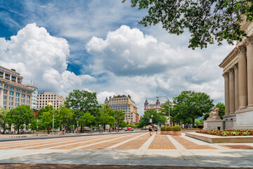 Dramatic clouds rise above a wide brick plaza in downtown Washington DC. © kosoff