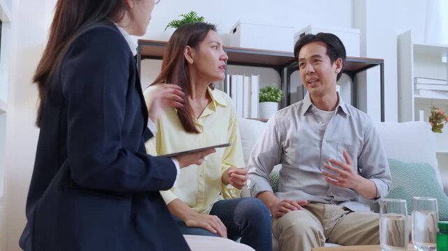 Asian couple arguing with therapist during home consultation, frustrated wife talking to psychologist, stressed husband to relationship disagreement, psychological stress causing anxiety and problem.