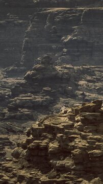 Towering rock formations emerge from the earth, their rugged textures illuminated by the gentle morning light. Shadows dance across the landscape, creating a mystical atmosphere.