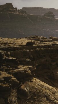 Waves of rugged rocks stretch across the terrain, bathed in soft golden light as the sun sets. The scene captures the essence of tranquility and natural wonder in a serene landscape.
