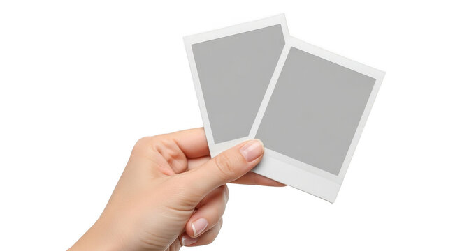 Hand holding two blank vintage style polaroid photo frames isolated on transparent background