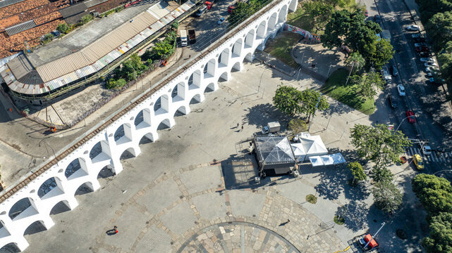 Arcos da Lapa featuring its iconic white arches stretching across the urban landscape with surrounding buildings and clear sky in Rio de Janeiro, Rio de Janeiro, Brazil. Aerial view.
