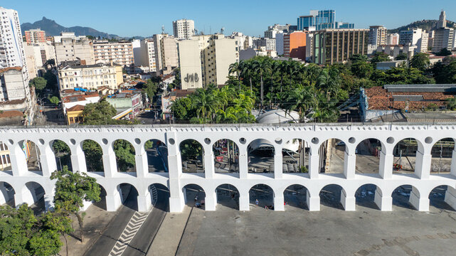 Arcos da Lapa featuring its iconic white arches stretching across the urban landscape with surrounding buildings and clear sky in Rio de Janeiro, Rio de Janeiro, Brazil. Aerial view.