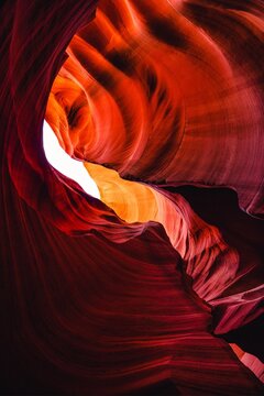 Swirling red and orange sandstone rock formations illuminated inside narrow slot canyon gorge