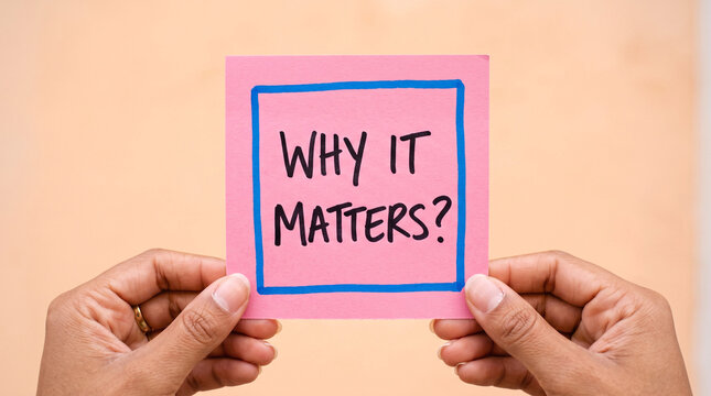 Person holding small pink square paper note with handwritten text asking why it matters as conceptual business reflection on strategic choices.