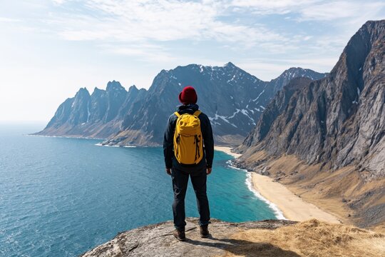 Hiker enjoying scenic hiking adventure on senja norway mountains above ocean beach