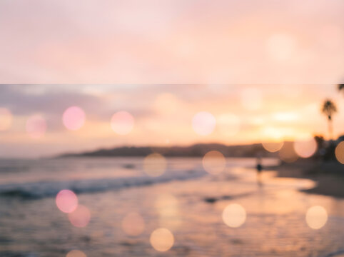 Dreamy bokeh sunset beach background with soft pink and golden light, blurred tropical ocean shore landscape at dusk. Ethereal out of focus coastal scenery featuring warm sunset glow and