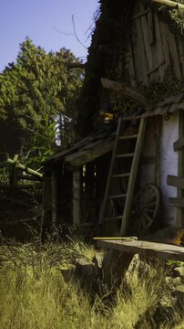 Sunlight kisses the weathered cabin nestled among lush greenery. Natures charm envelops an old ladder and wooden wheels, inspiring peaceful moments in a serene countryside setting.