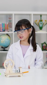 Elementary Student in Lab Coat Conducting Science Experiment in Classroom
