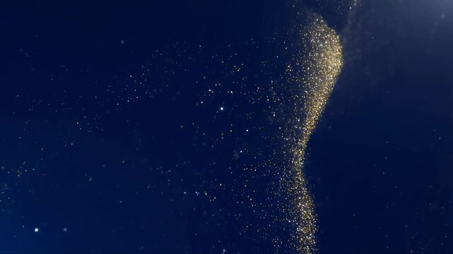 Golden glitter particles cascading gracefully against deep blue sky background with particulate