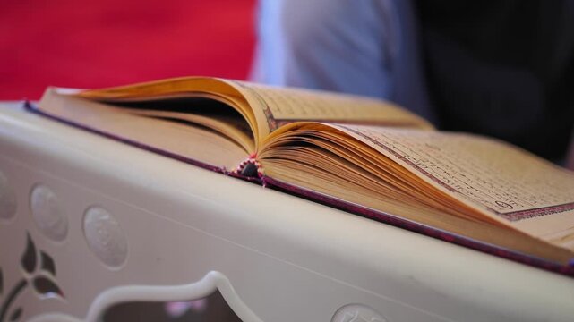 Reading a quran in a mosque on a table indoors