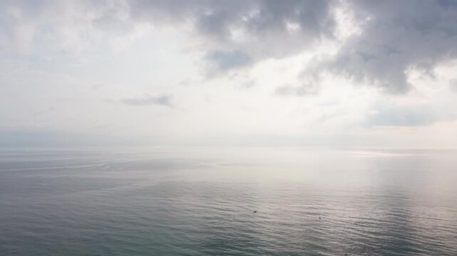 At Tuy Hoa Beach in Vietnam, the ocean waves gently meet the shore under a cloudy sky. The water reflects soft colours as the day unfolds. Visitors can relax and enjoy the view.