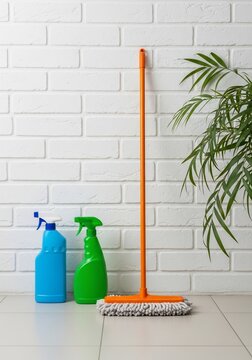 Clean Sweep: Brite Bottles & Broom Against Textured Wall
