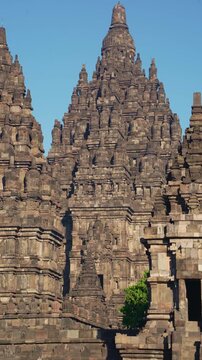 Clustered Prambanan Temple towers display elaborate stone carvings and dramatic Hindu architecture beneath a brilliant blue sky.
