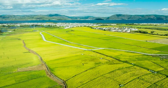 Aerial time‑lapse of Xizhou ancient town in Dali Yunnan, rice fields, villages and mountain landscape
