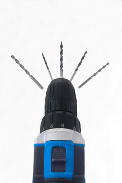 Powerful drill with multiple bits protruding upward. Clean background emphasizes tool's professional design. Ideal for construction, DIY, or workshop visuals. Creative close up of blue black cordless 