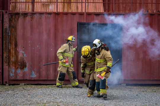 Team of firefighter in fireproof clothe are escaping the burning building with injured buddy for fire extinguish risk rescue mission and accident management usage