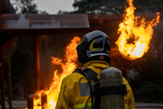 Team of firefighter in fireproof cloth using fog watering hose to put out the burning crashing plane with high flame for fire extinguish risk rescue mission and accident