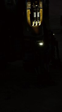 A sleek, futuristic vehicle stands illuminated at night, with glowing lights highlighting its design. The scene evokes a sense of adventure and technology under a starry sky.