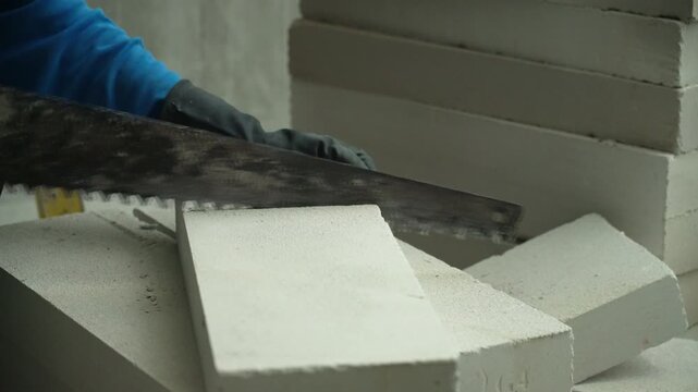 Close-up of cutting an AAC lightweight concrete block with a saw.