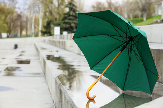 Green umbrella on puddle outdoors