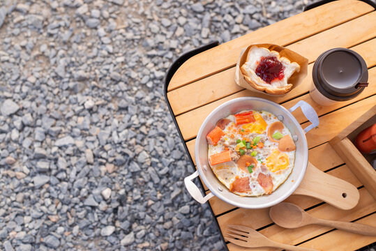 Delicious flatlay of picnic food including fried eggs, bread and coffee cup on nature trip, real image, not AI generated.