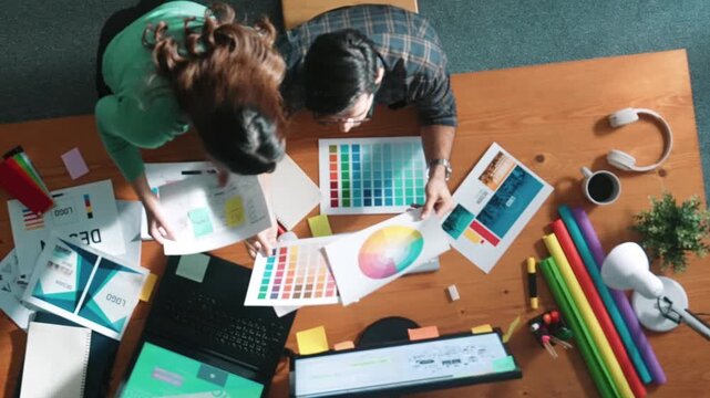 Top view of project manager looking at screen while designer writing idea. Close up of smart business team explain idea of logo design while designer choose theme while looking at palette. Symposium.