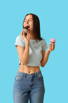 Young woman with sweet cupcakes on blue background. Valentines Day celebration