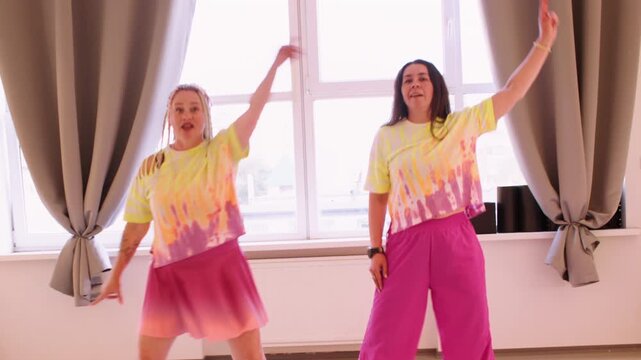 Amusing performance. Comedian activity. Woman in bright colorful clothes training synchronous movement in studio for party music show.