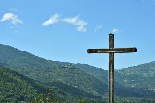 Cruz ubicada en lo Alto del Cerro de la Cruz en Antigua Guatemala, al fondo monta&ntilde;as y el cielo azul despejado.
