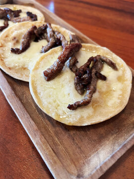 Tortillas con queso derretido y carne asada.