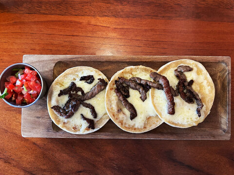 Tortillas con queso derretido y carne asada, acompa&ntilde;adas de tomate tipo pico de gallo. Toma Superior.