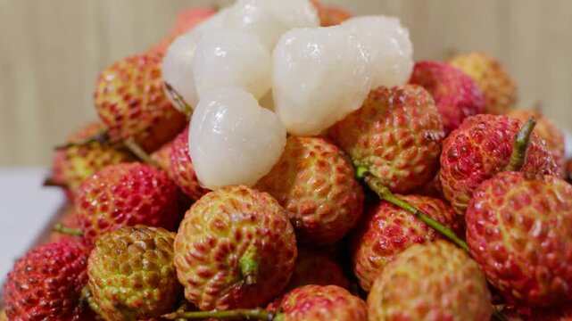 Peeled and unpeeled lychees placed together. Close-up shot of lychee fruits.