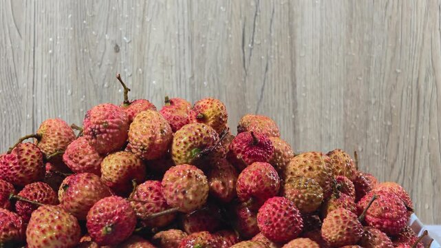 Clear water pouring over lychees to wash them.