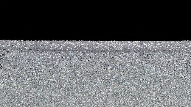 Silver particles rising from bottom against black background