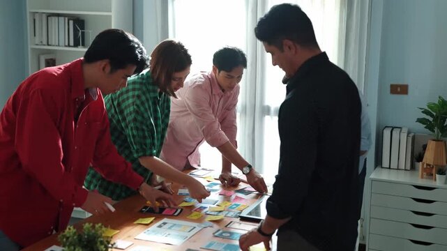 Top view of diverse business people discussing idea and designing system while using tablet with Ux, Ui design display on screen. Multicultural working together and planning strategy. Convocation.