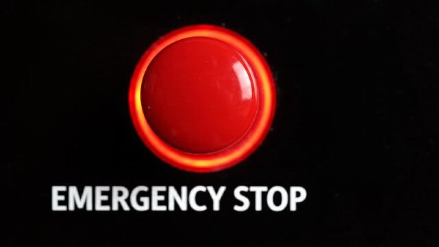 Red emergency stop button on industrial machinery close up