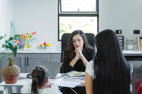 Female professional consulting with mother and daughter in office