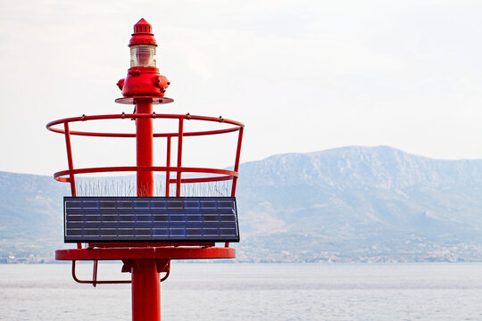 Solar-Powered Red Marine Navigation Beacon by the Water