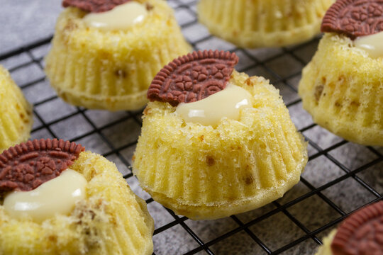 Steamed sponge cakes or bolu kukus topped with creamy white vla filling and red oreo cookies