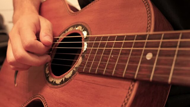 Close up musician playing acoustic guitar strings