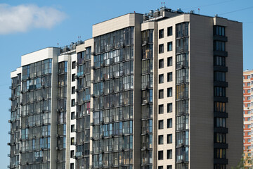 Fototapeta premium Modern apartment building with large windows in an urban area during daytime