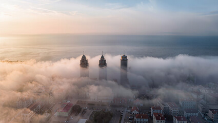 Fototapeta premium Misty Sunrise Over Coastal Buildings