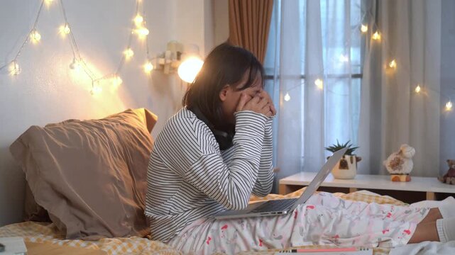 Young girl was using laptop and eyes were so tired had to take a nap in comfortable bedroom