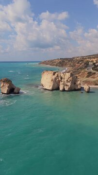 Aerial view of Aphrodite rock and turquoise sea in Paphos Cyprus featuring limestone formations and mediterranean coastline.