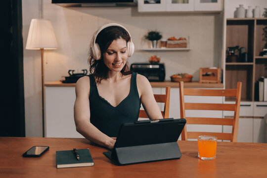 Woman preparing green smoothie in bright kitchen with fresh fruits and vegetables, healthy eating lifestyle moment in natural daylight